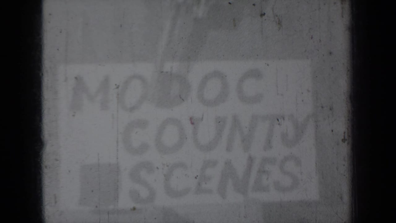 Soft, dark 8mm frame with a faint hand-lettered Modoc County Scenes title card.