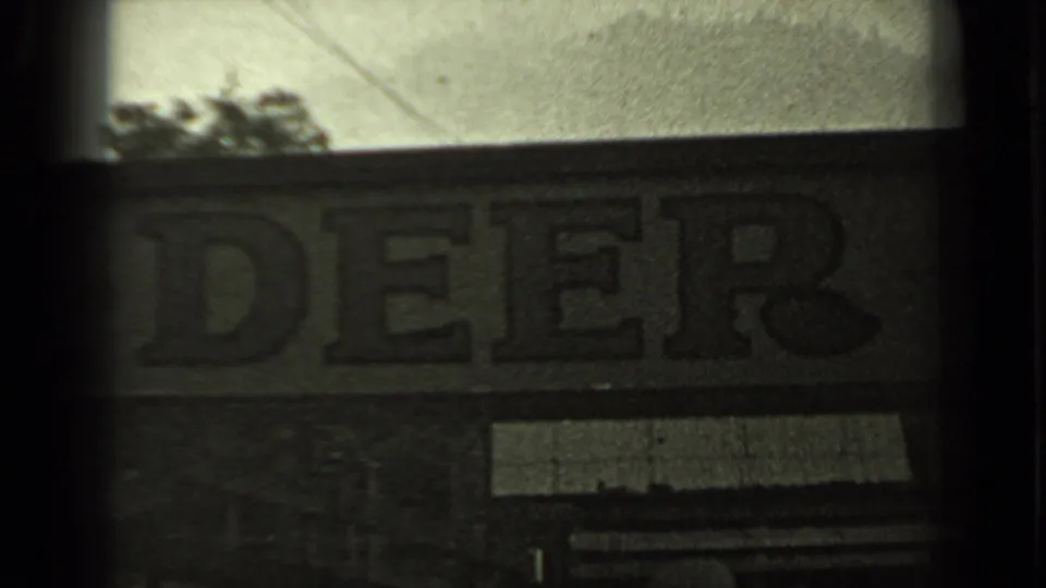 Close 1937 Klamath-area frame of the Mule Deer Bar sign, partially cropped by dark gate edges and soft exposure.