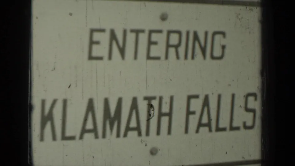 Second 1937 Klamath-area frame of the Entering Klamath Falls sign, slightly darker and framed by visible film edges.