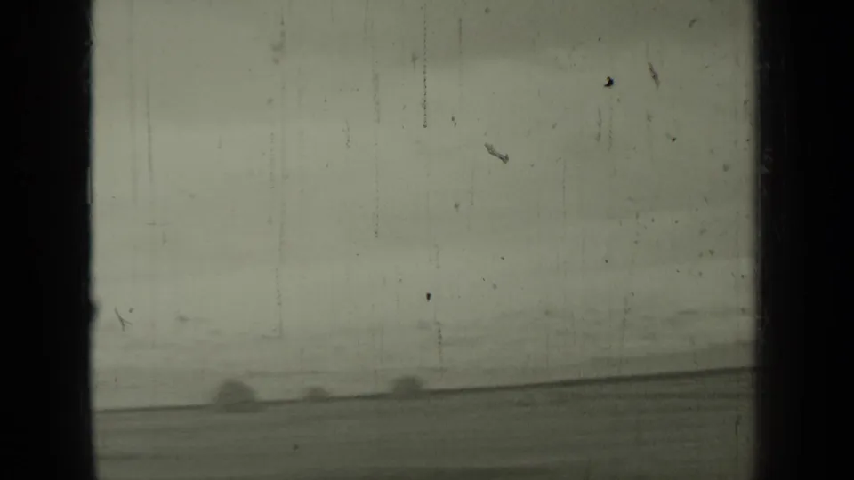 1937 Klamath, California frame with faint bird movement, distant hay bales, and dark film or window framing around the rural view.