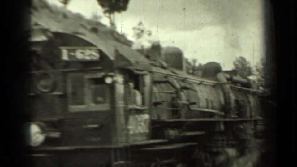 Close 8mm view of a steam locomotive passing in Klamath, California, with identifying numerals on the cab area.