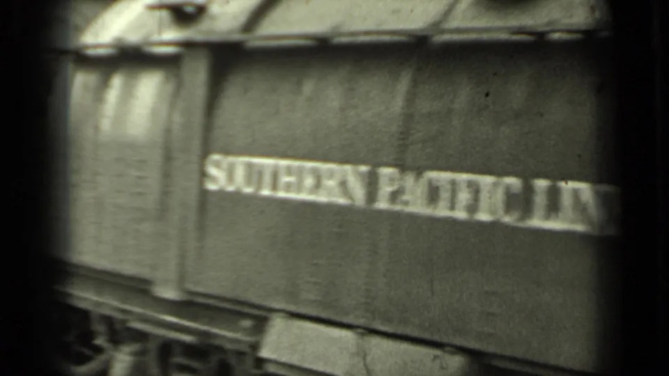 Close 1937 Klamath, California view of Southern Pacific Lines lettering on a passing rail car in grainy 8mm footage.
