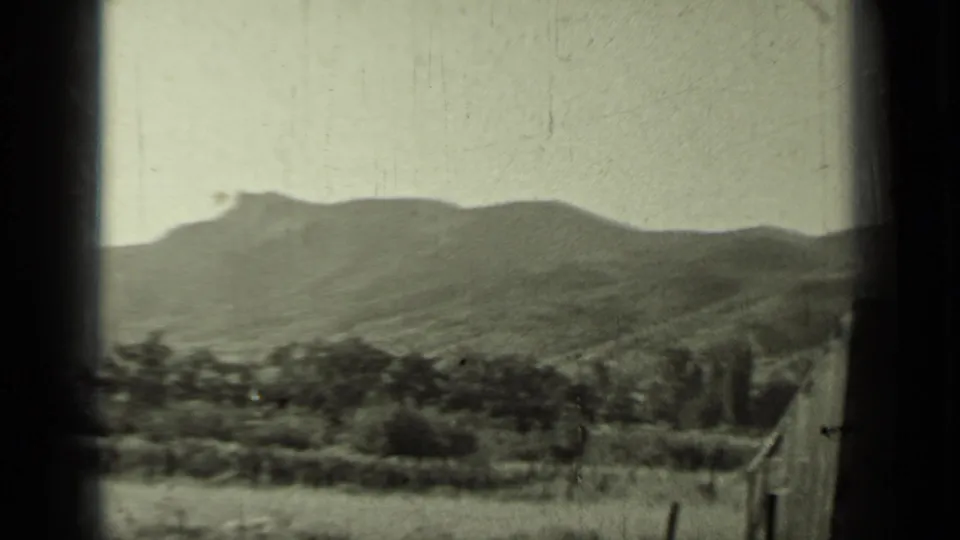 1937 Klamath, California home-movie landscape with low vegetation, rolling hills, and a distant mountain ridge under a pale sky.
