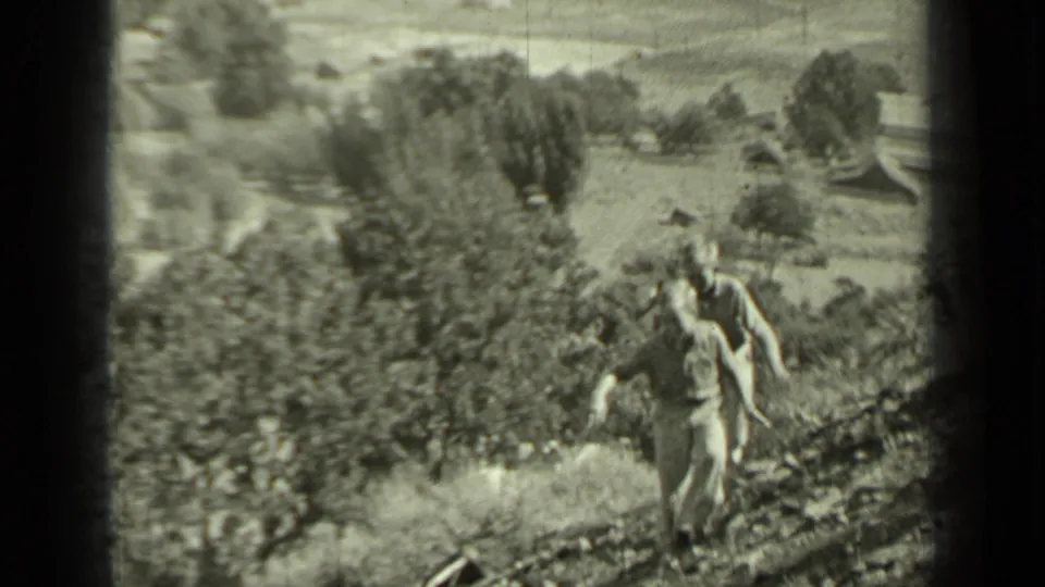 In 1937 Klamath, California home-movie footage, two young people run uphill toward the camera across a rural slope.