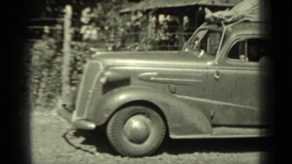 1937 Klamath, California frame of the front half of a parked vintage car, with rounded fender, wheel, and driver window visible.