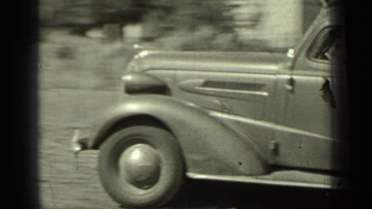 Side detail of a period automobile passing through the Klamath, California roadside scene.
