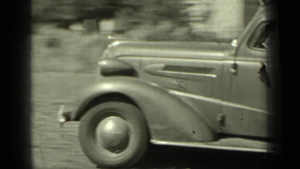 Side detail of a period automobile passing through the Klamath, California roadside scene.