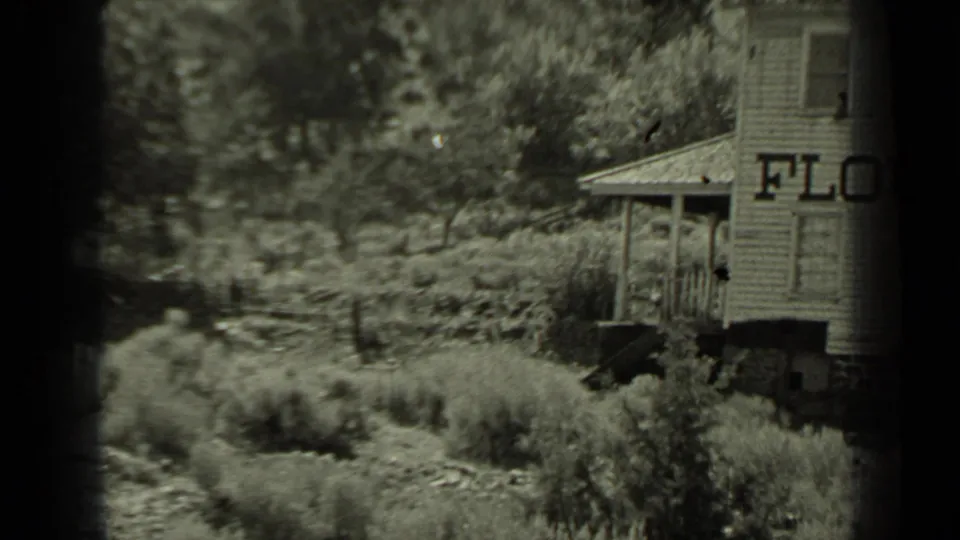 A small roadside structure with partial lettering appears beside trees and brush in Klamath, California.