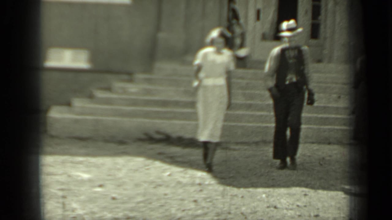 The man and woman continue walking away from the steps toward the camera.