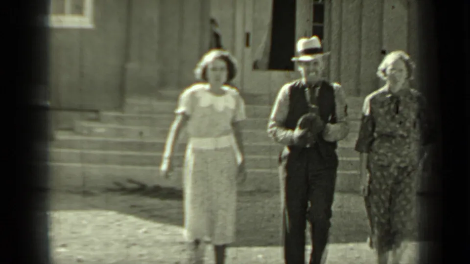 A second woman joins the man and woman as they walk toward the camera outside the Klamath building in 1937.