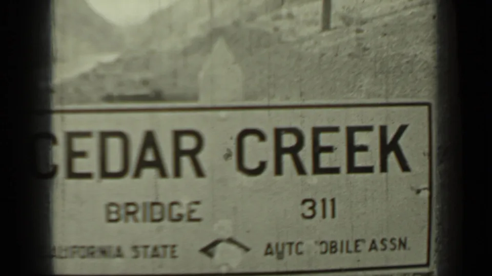 1937 Klamath, California frame showing a weathered Cedar Creek Bridge sign with partially visible California State Automobile Assn. text.