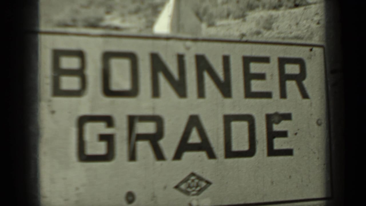 Bonner Grade road sign fills the frame beside a rocky hillside.
