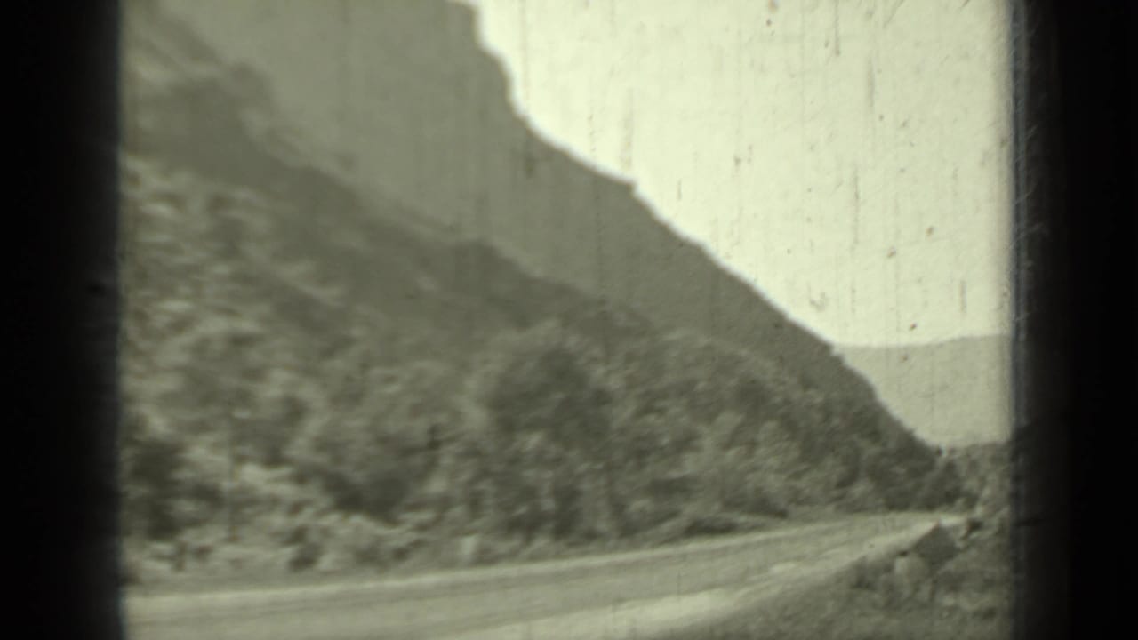 1937 Klamath, California road view with a mountain slope, pale sky, and soft 8mm home-movie framing.