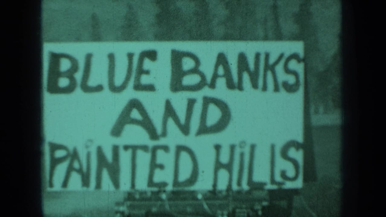 1937 Medford, Oregon 8mm frame showing a hand-painted Blue Banks and Painted Hills sign with soft focus and greenish tint.
