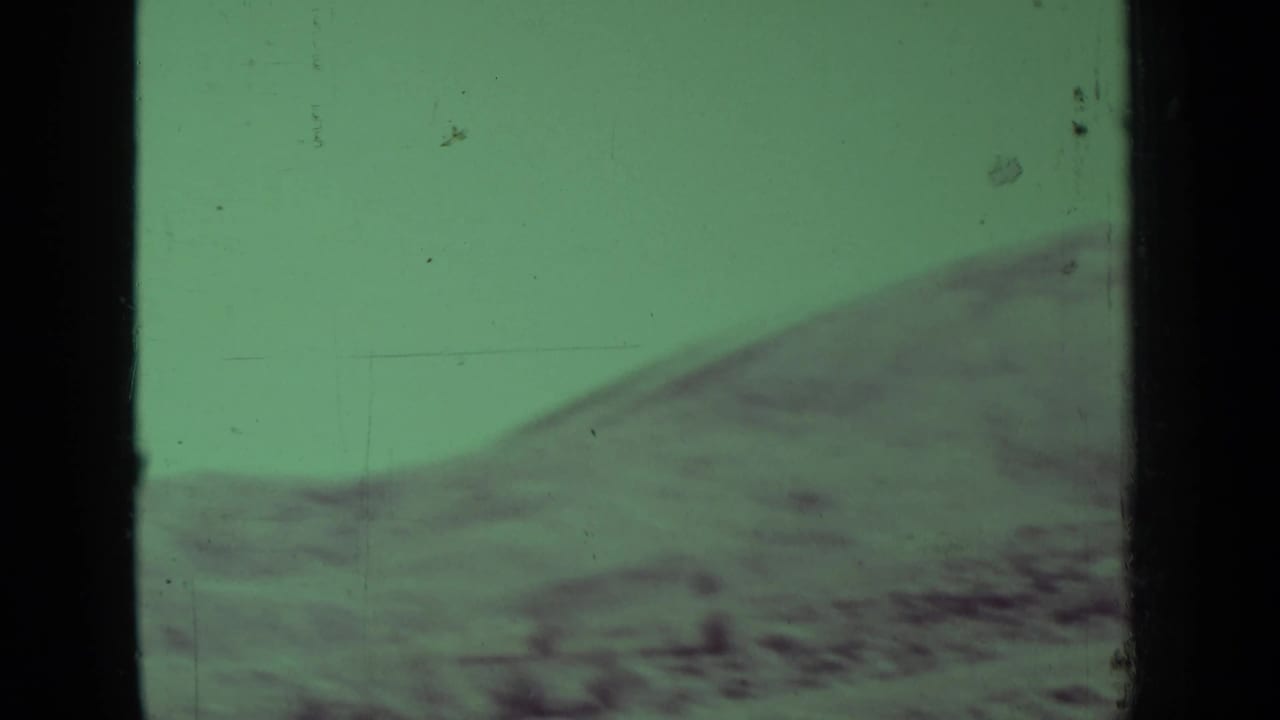 Green-tinted rolling hillside seen through an 8mm frame border.