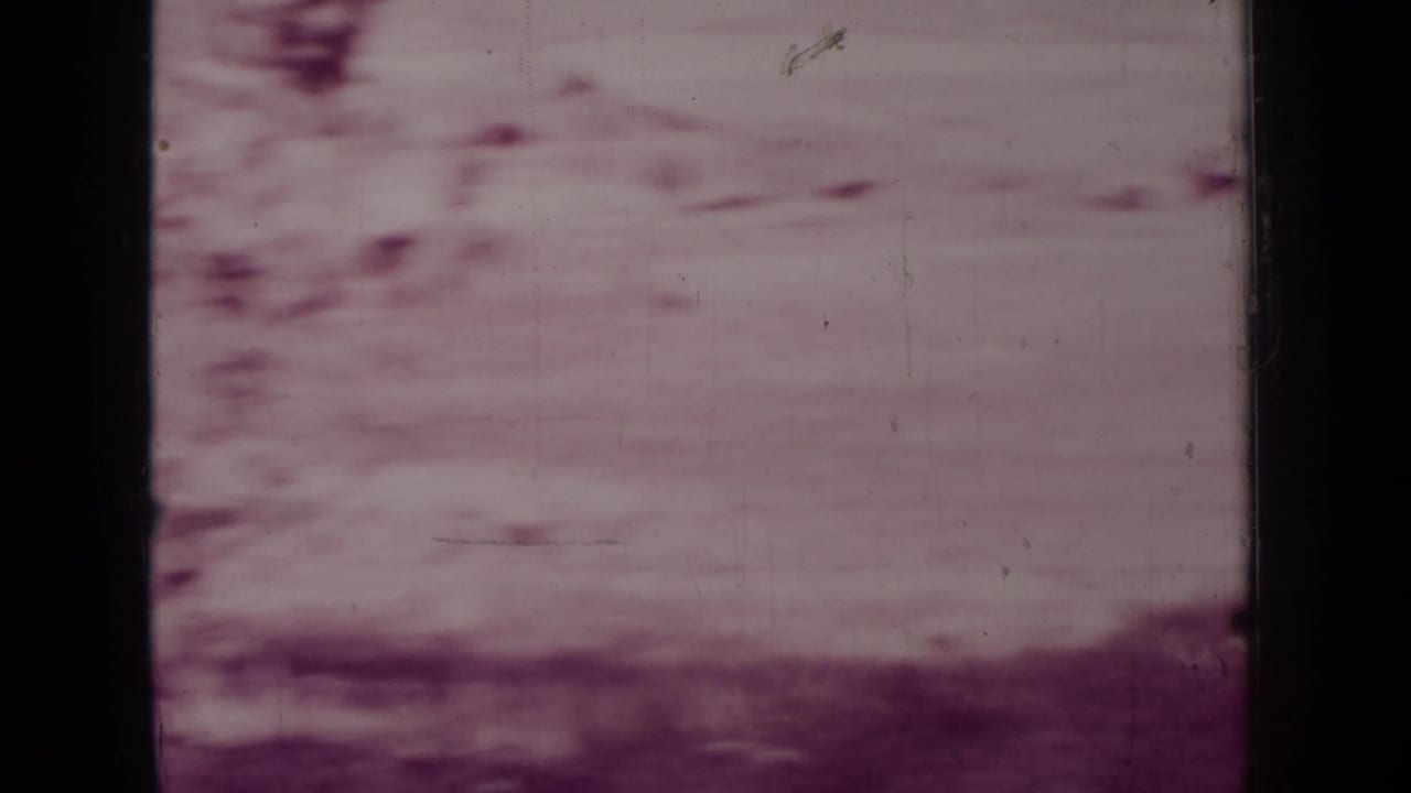 Faded, soft view of pale open ground with dark film borders.