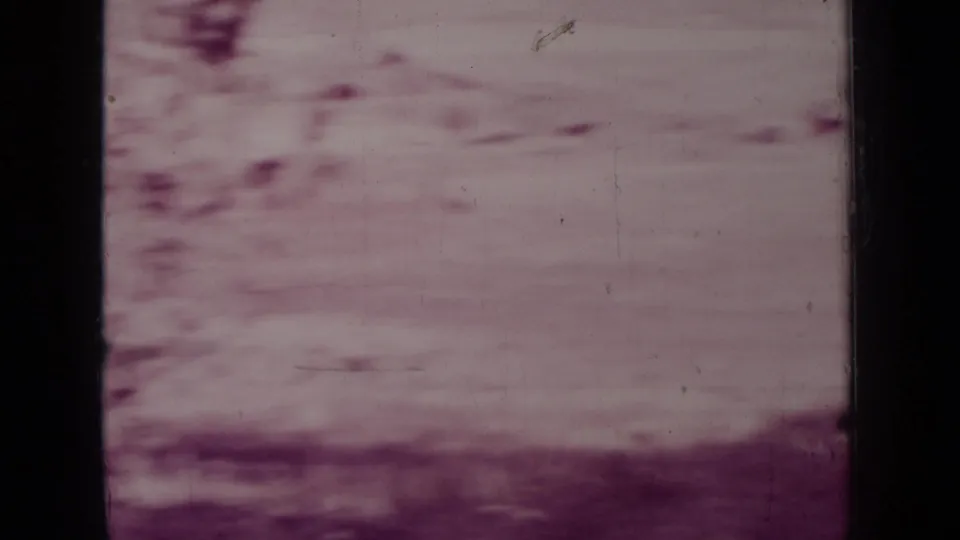 Faded 1937 8mm frame from the Medford, Oregon clip showing an indistinct dry landscape through heavy grain and dye shift.
