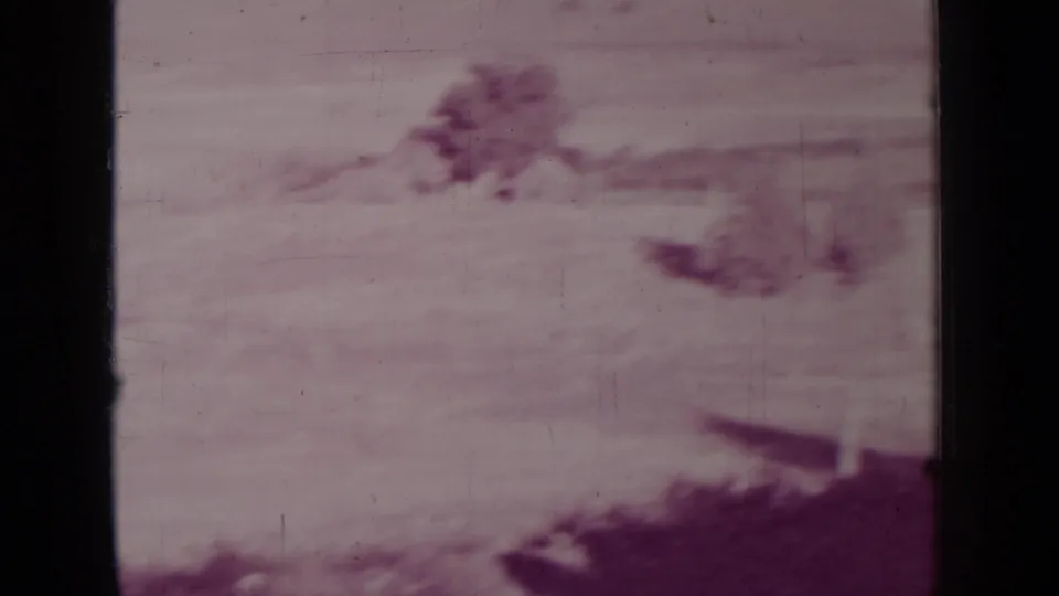 Faded 1937 8mm frame from the Medford, Oregon clip showing distant hills or mountains beneath a hazy sky.