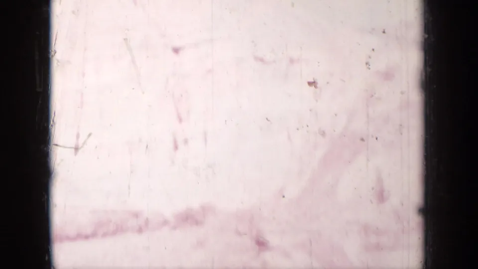 Overexposed 1937 8mm frame near Medford, Oregon, with scratches, dust, and only faint traces of the landscape visible.