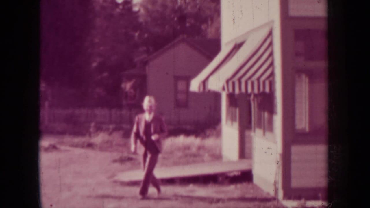 Man in a suit walks away from the storefront toward the camera.