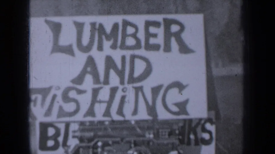 1930s Medford, Oregon frame of a hand-lettered black and white sign with LUMBER AND FISHING text and partial lower lettering.