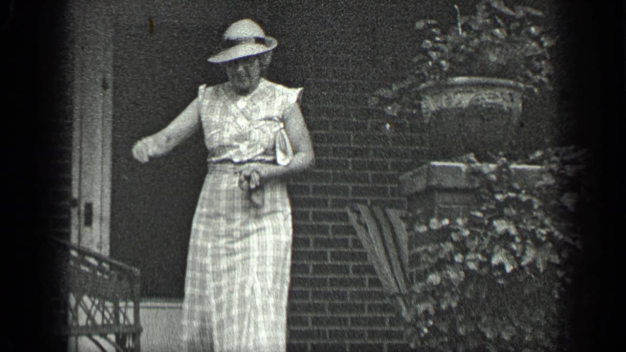 Woman in a light dress and wide-brimmed hat stands near brick porch steps.