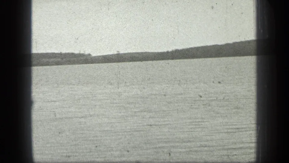 1939 8mm home-movie frame of Long Lake, Canada, showing rippled water, a low far shore, pale sky, and dark gate borders.