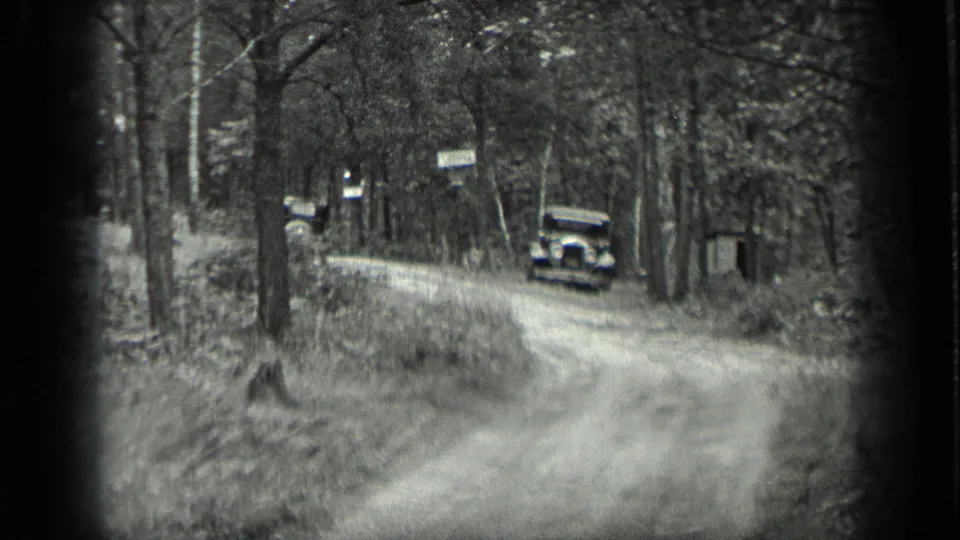 Long Lake roadside view from 1939 with a vintage car on a dirt lane, trees on both sides, and small signs near the road.