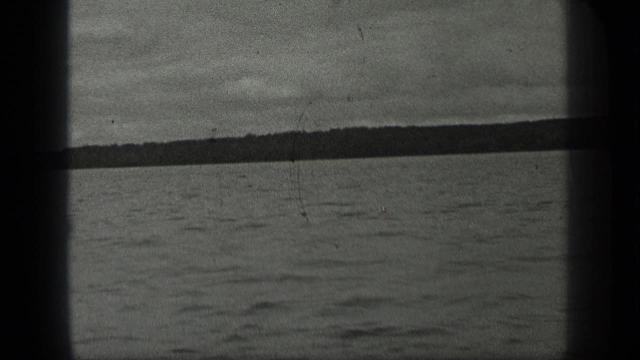 Long Lake, Canada view with calm water, distant tree-lined shore, and overcast sky in 1939 8mm footage.