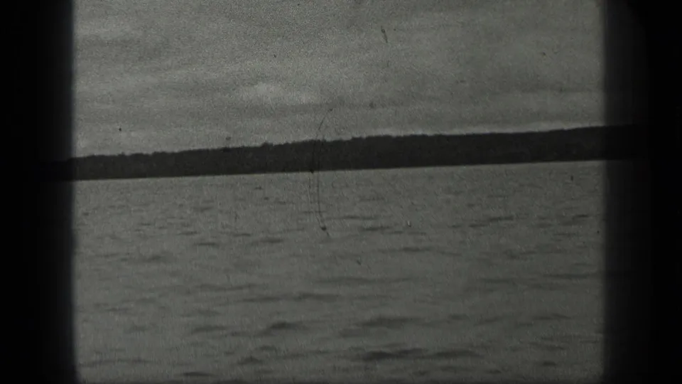 Long Lake, Canada view with calm water, distant tree-lined shore, and overcast sky in 1939 8mm footage.