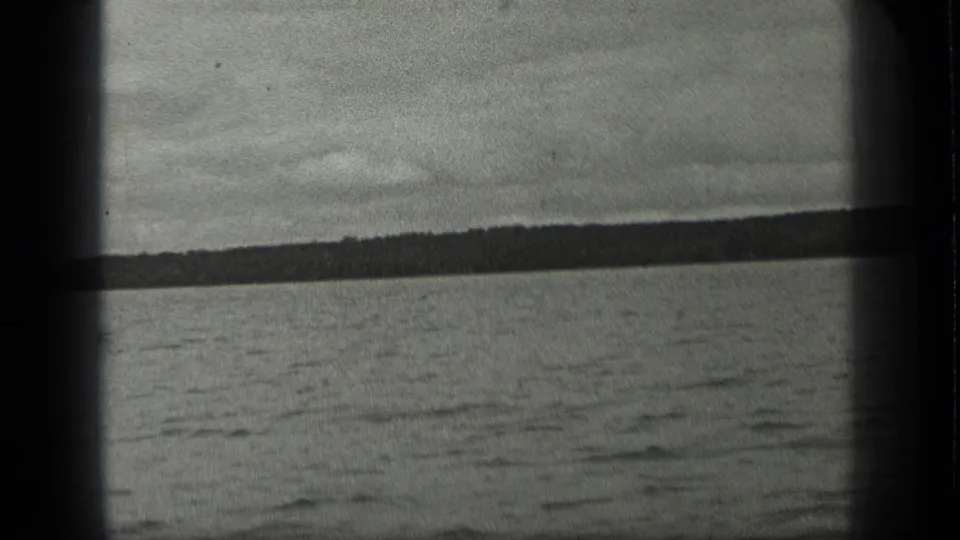 Wide 1939 Long Lake, Canada shot showing rippled water and a low tree-covered shore under gray sky.