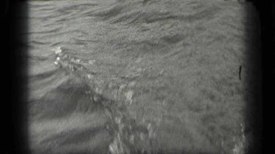 Long Lake, Canada, seen in black-and-white 8mm with a rippled lake surface and distant shoreline band.
