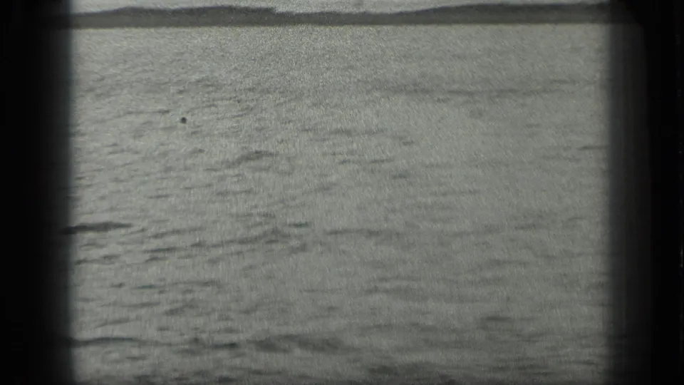 Wide 1939 8mm view over Long Lake, Canada, with calm water and a distant wooded shoreline.