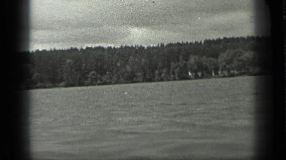 Slightly tilted 1939 home-movie view of Long Lake water and a wooded Canadian shoreline.