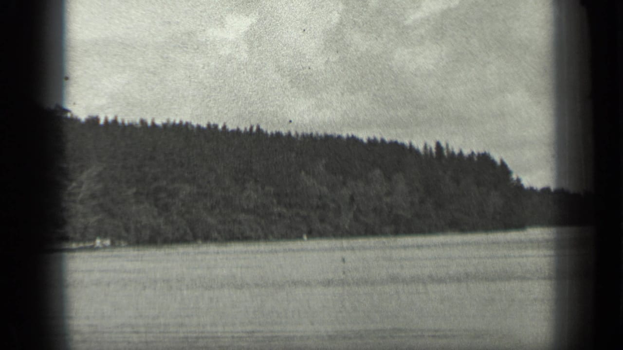 1939 Long Lake, Canada footage showing calm water, a dark treeline, low hills, and an overcast sky within an 8mm frame.