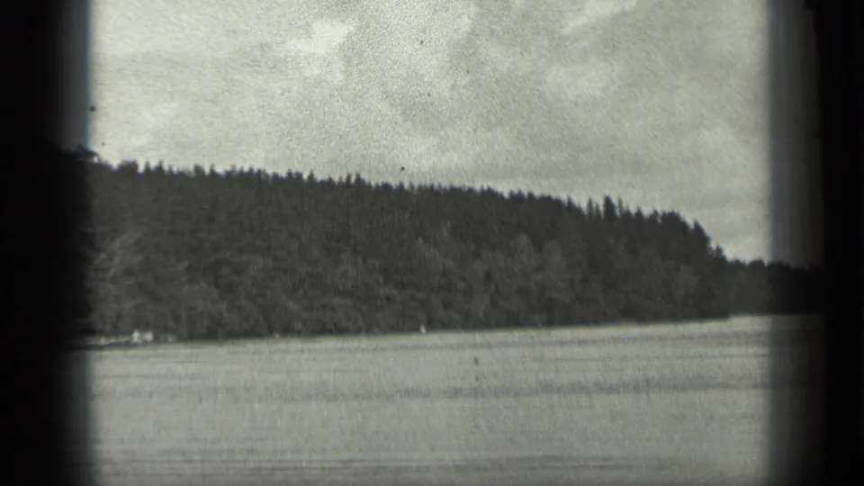 1939 Long Lake, Canada footage showing calm water, a dark treeline, low hills, and an overcast sky within an 8mm frame.
