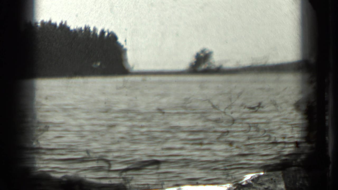Long Lake, Canada, in 1939 home-movie footage, with soft ripples, wooded shore, and a bright open sky.