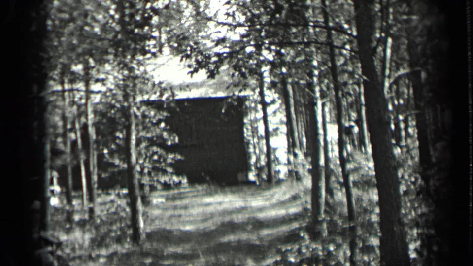 1939 Long Lake, Canada home-movie frame showing a rustic cabin at the end of a narrow wooded driveway.