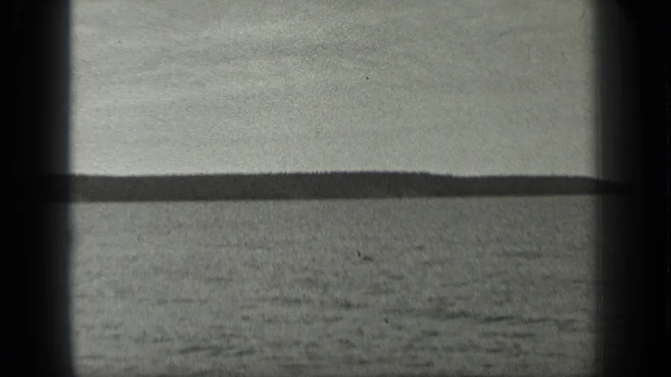 1939 Long Lake, Canada view across open water toward a low wooded shoreline, with soft focus and dark 8mm frame edges.