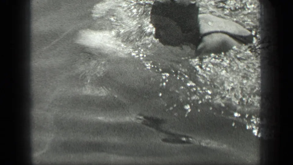 In 1939 Long Lake, Canada footage, a swim-capped person moves through rippling water in a close, grainy 8mm frame.
