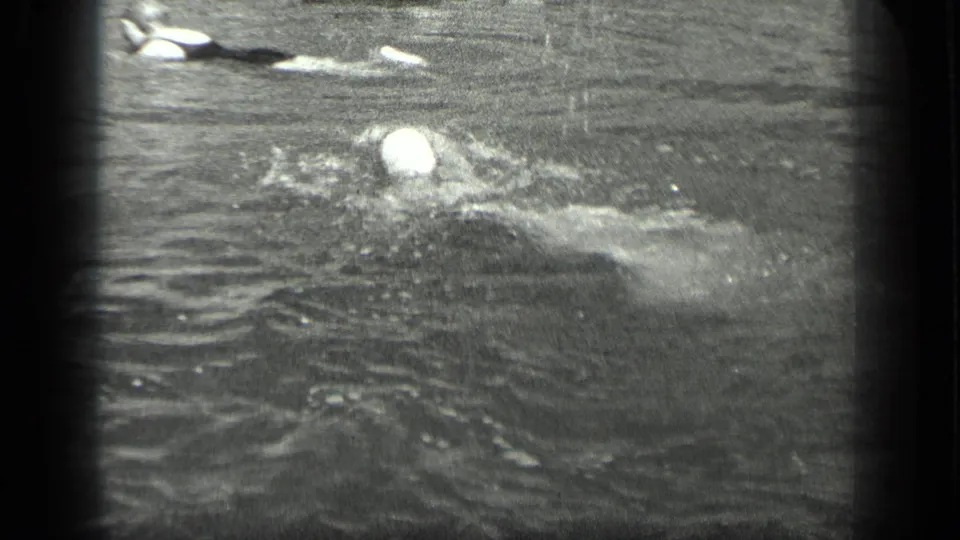 Capped swimmer in Long Lake, Canada, seen in soft 8mm black-and-white footage from 1939.