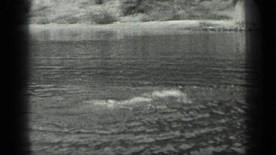 The swimmer remains partly submerged in the 1939 Long Lake scene, creating a low wake across the water.