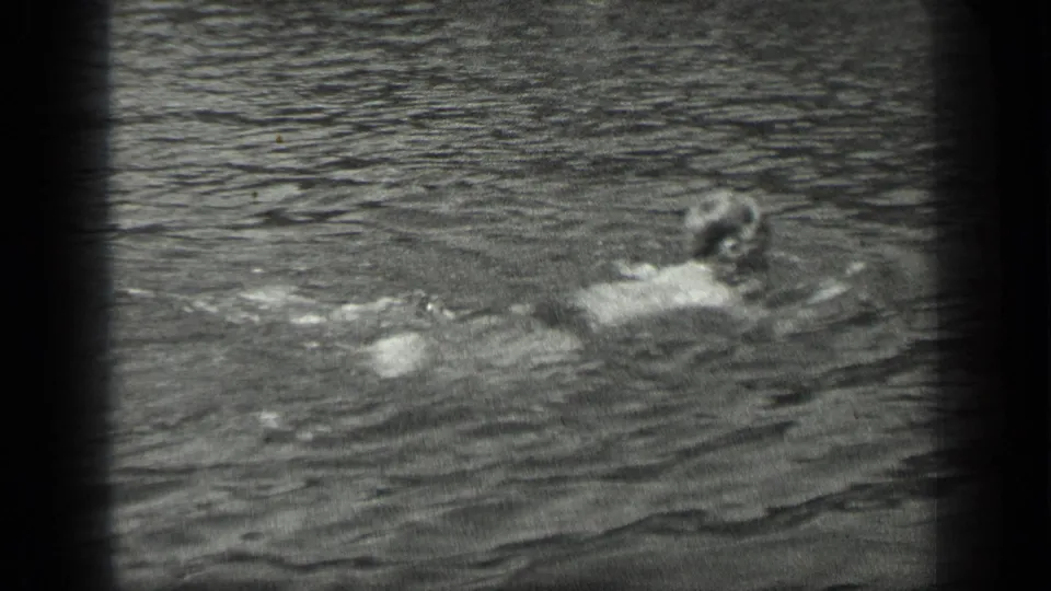 A swimmer moves across the surface of Long Lake, Canada, in grainy black-and-white 8mm footage from 1939.