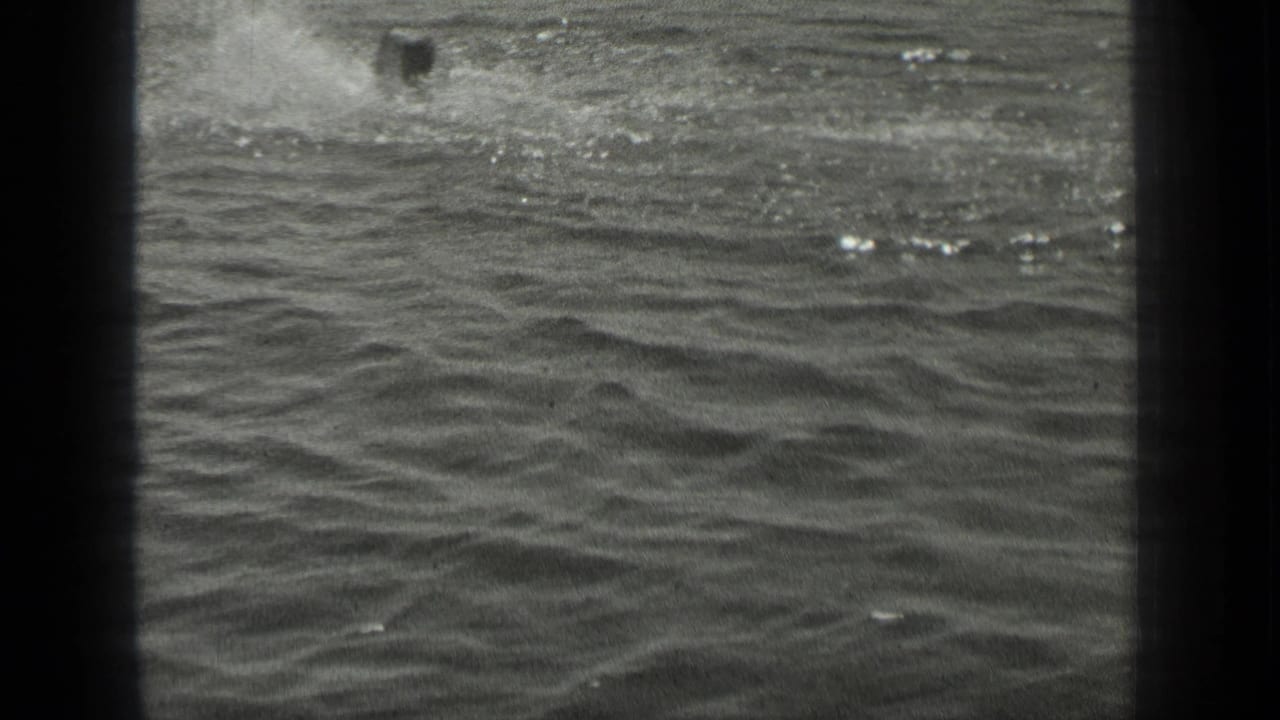 A late moment in the 1939 Long Lake, Canada clip shows a distant swimmer near a splash trail, with open rippling water in the foreground.