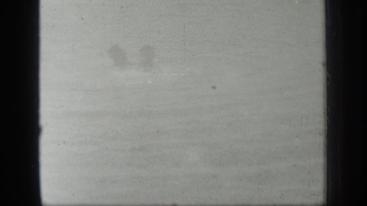 Soft, overexposed 1939 Long Lake, Canada frame with faint water texture and a barely visible swimmer shape near the upper left.