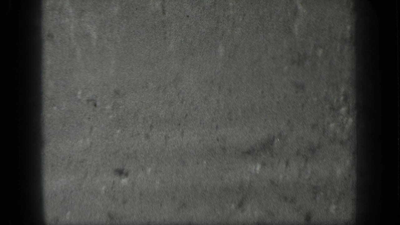 Close view of wet sand or shallow water with dark film gate edges.