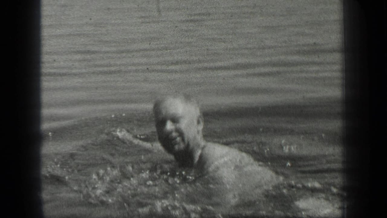 An older man faces the camera while swimming in metadata-supported 1939 Long Lake footage.