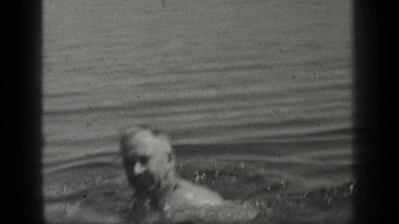 Adult man swims near the camera in Long Lake, Canada, in black-and-white 1939 8mm home-movie footage.