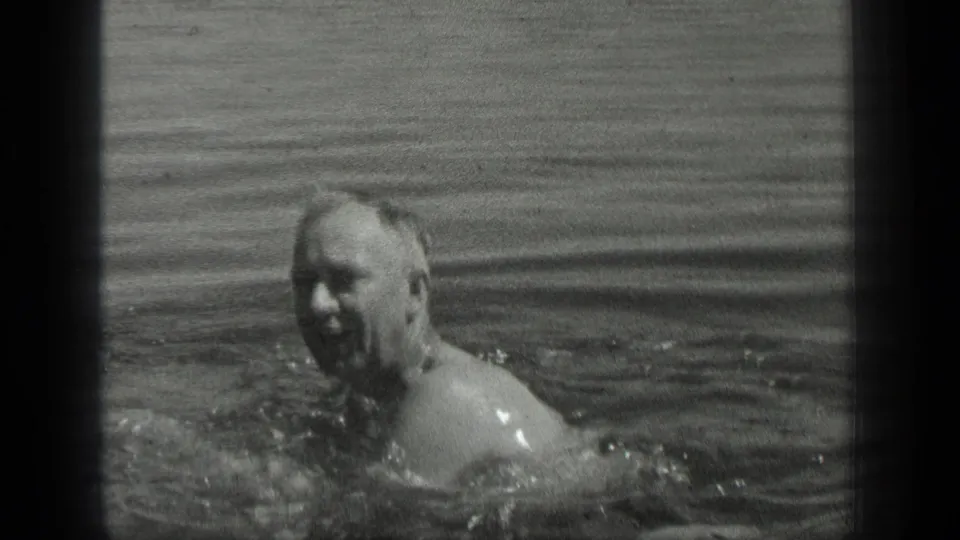 Adult male swimmer faces the camera in Long Lake, Canada, with his upper body partly visible above the water in 1939 8mm footage.