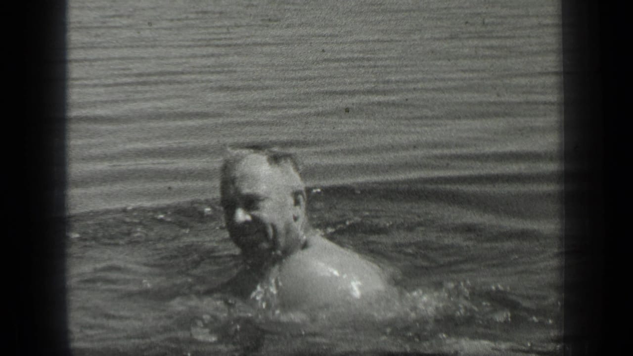 The adult swimmer appears to smile while moving through Long Lake, Canada, in a grainy 1939 8mm home movie frame.